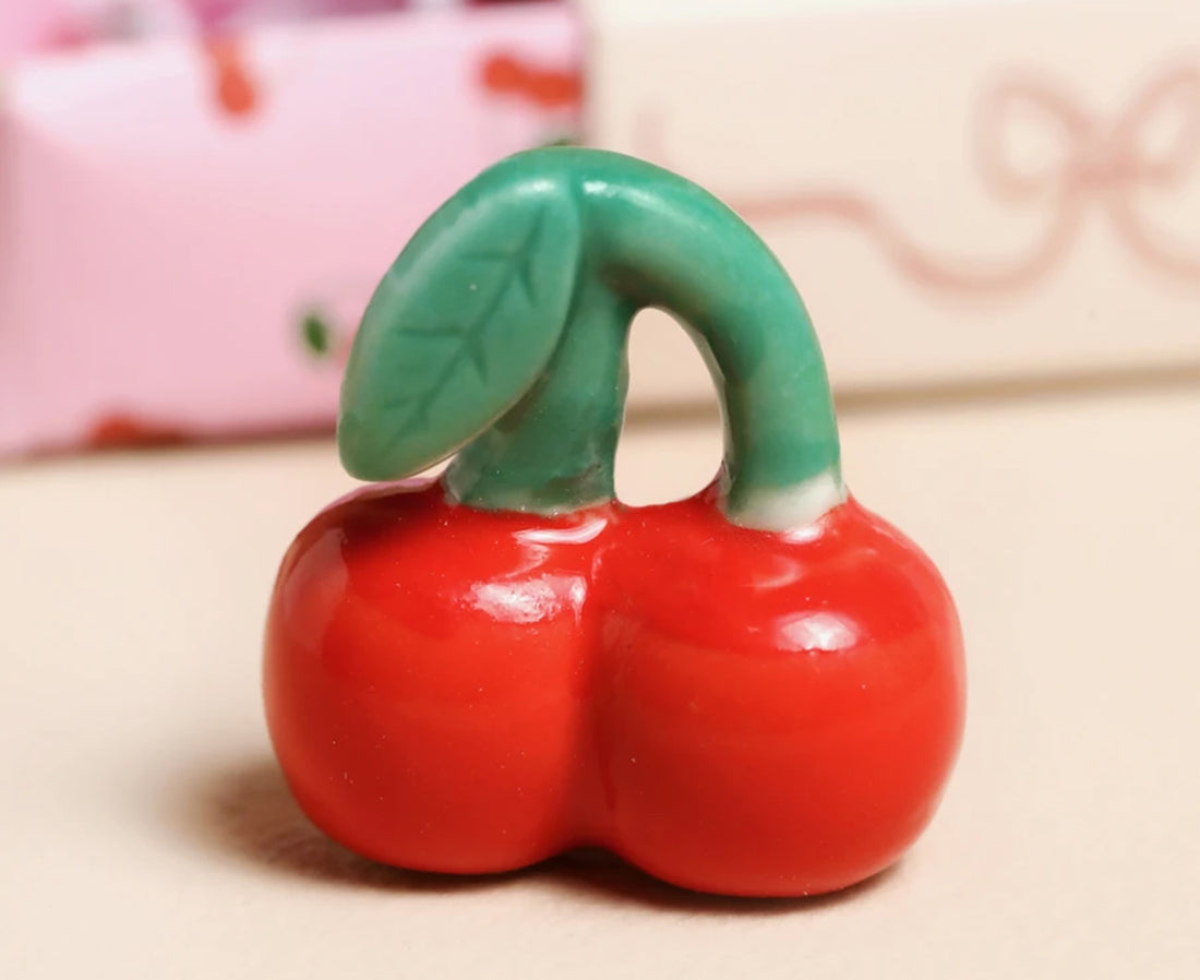 Ceramic red and green cherries.
