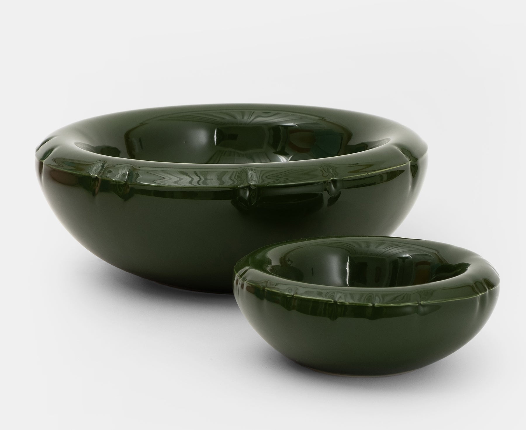 Two glossy dark green ceramic Blow Up bowls with flared rims and subtle embossed details.