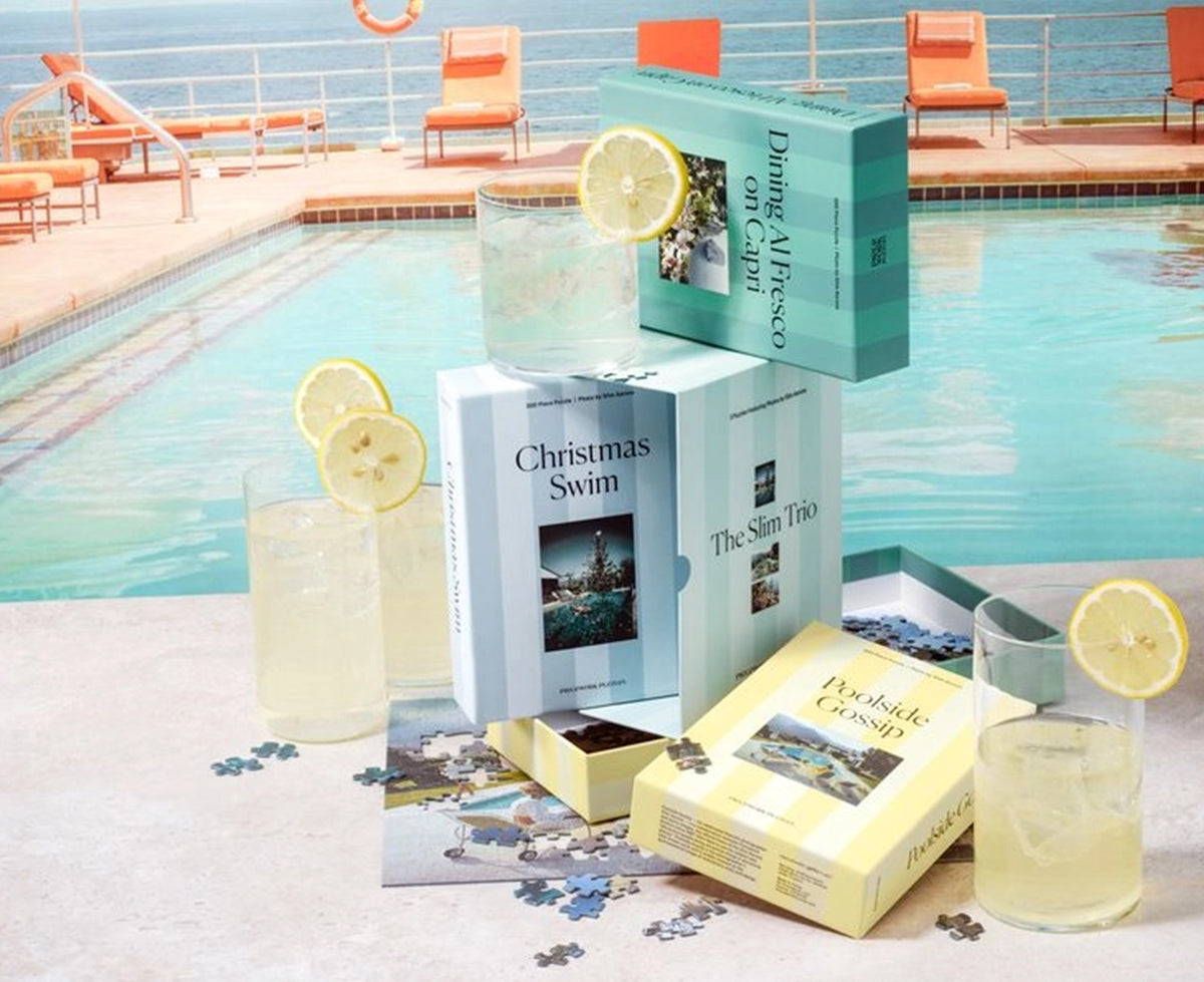 A curated poolside gift set featuring three boxed books or puzzle boxes labeled &