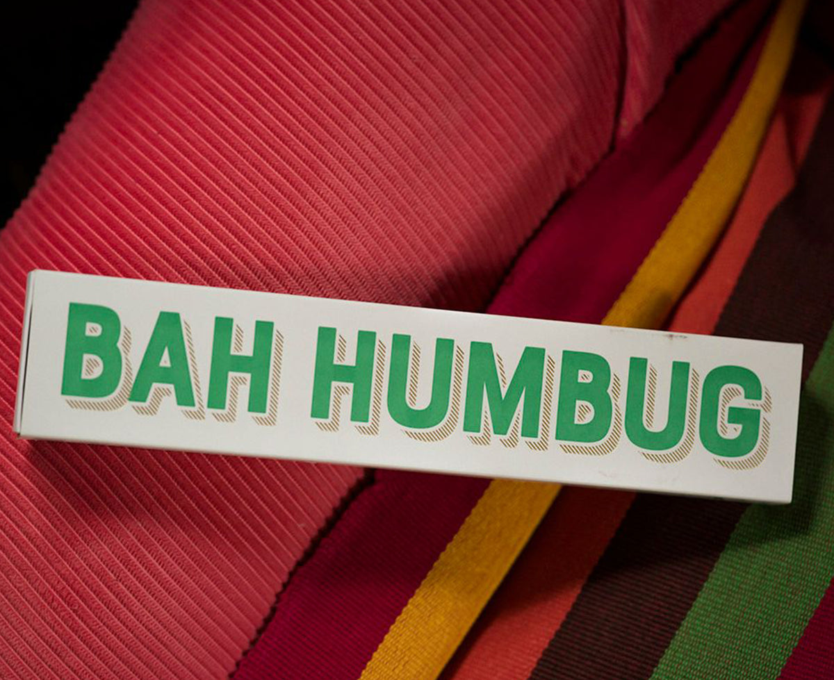 Green and gold boxed Long Matches Bah Humbug on a red facric background.