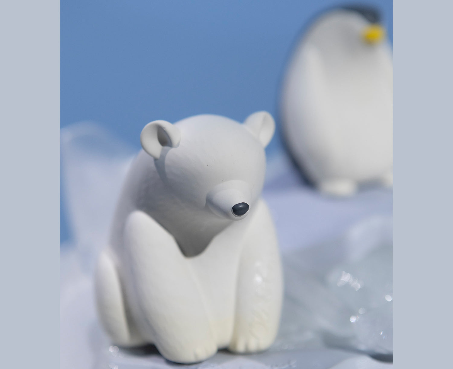 White polar bear chewable toy on a blue base of ice with Oli &amp; Carol branding.