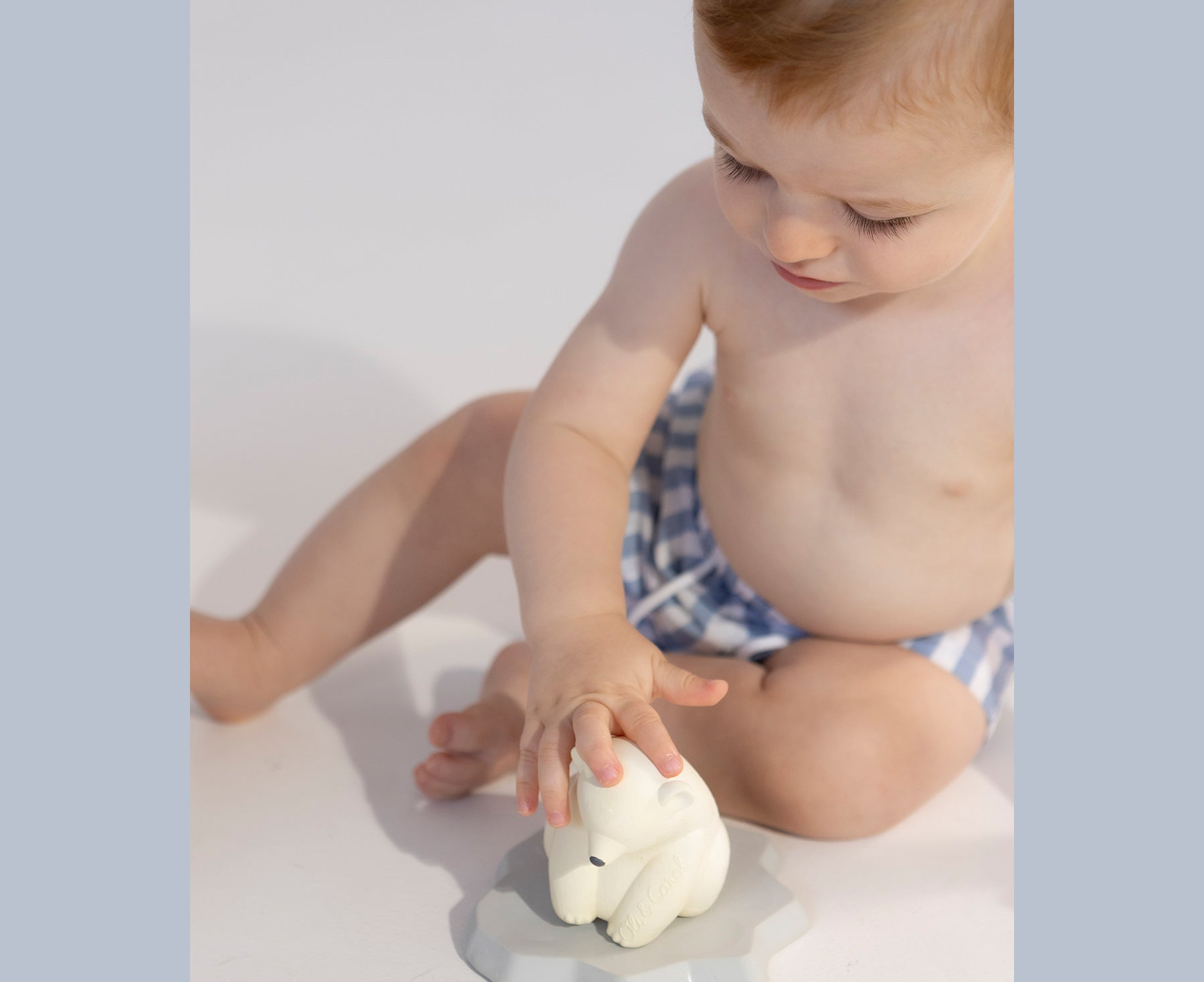 Child playing with the ice bear chewable toy with Oli &amp; Carol branding.