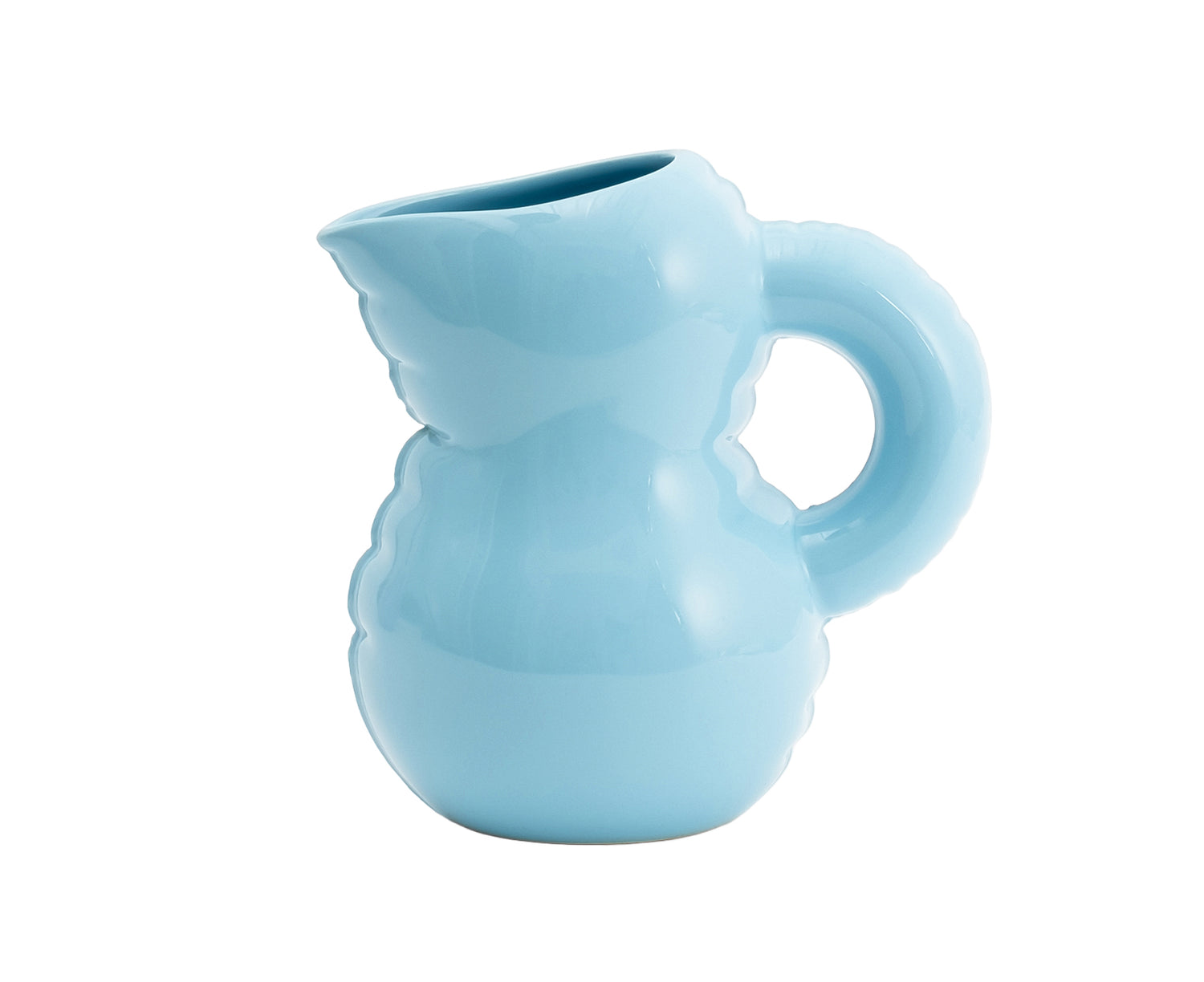 A light blue Blow Up ceramic pitcher by Home Studyo with a rounded, sculptural design, scalloped edges, and a curved handle.
