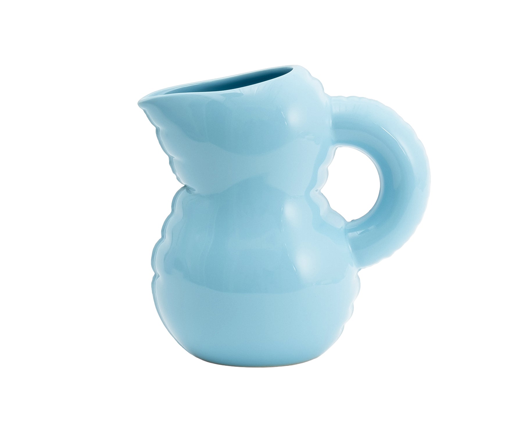A light blue Blow Up ceramic pitcher by Home Studyo with a rounded, sculptural design, scalloped edges, and a curved handle.