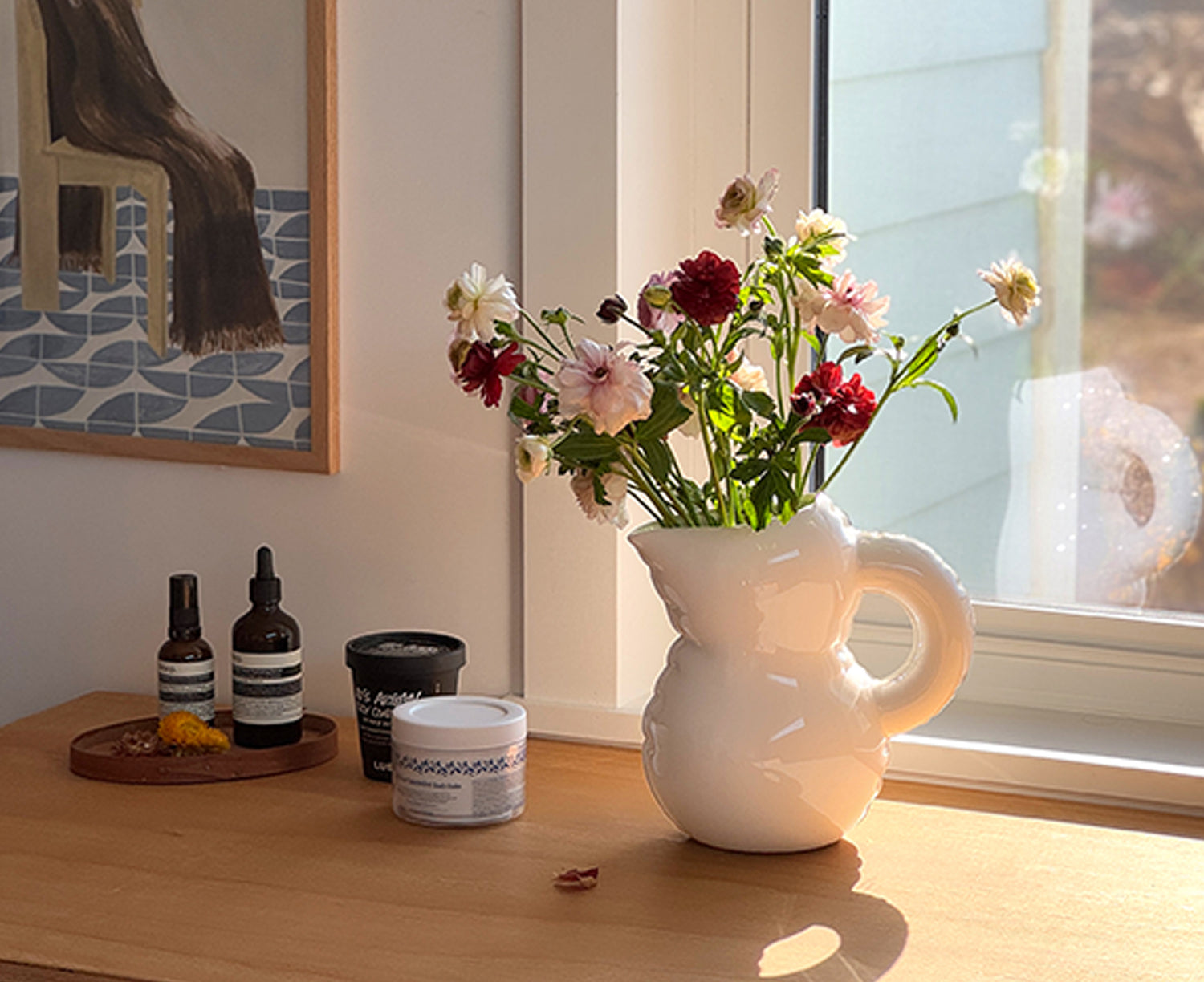 Emily Blow Up Jug in Bone by Home Studyo with a rounded, sculptural design, featuring a textured body holding flowers.