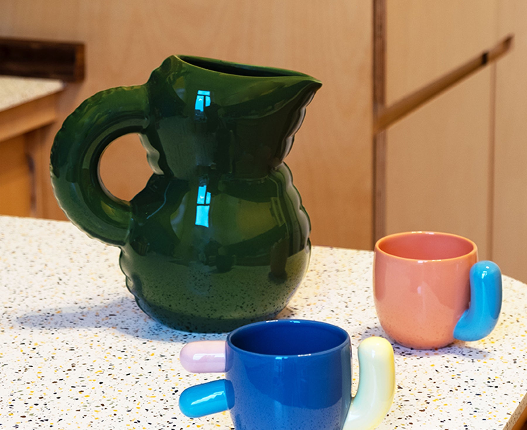 Emily Blow Up ceramic Jug in Moss Green by Home Studyo with a rounded body, ribbed texture, and a curved handle on a table.
