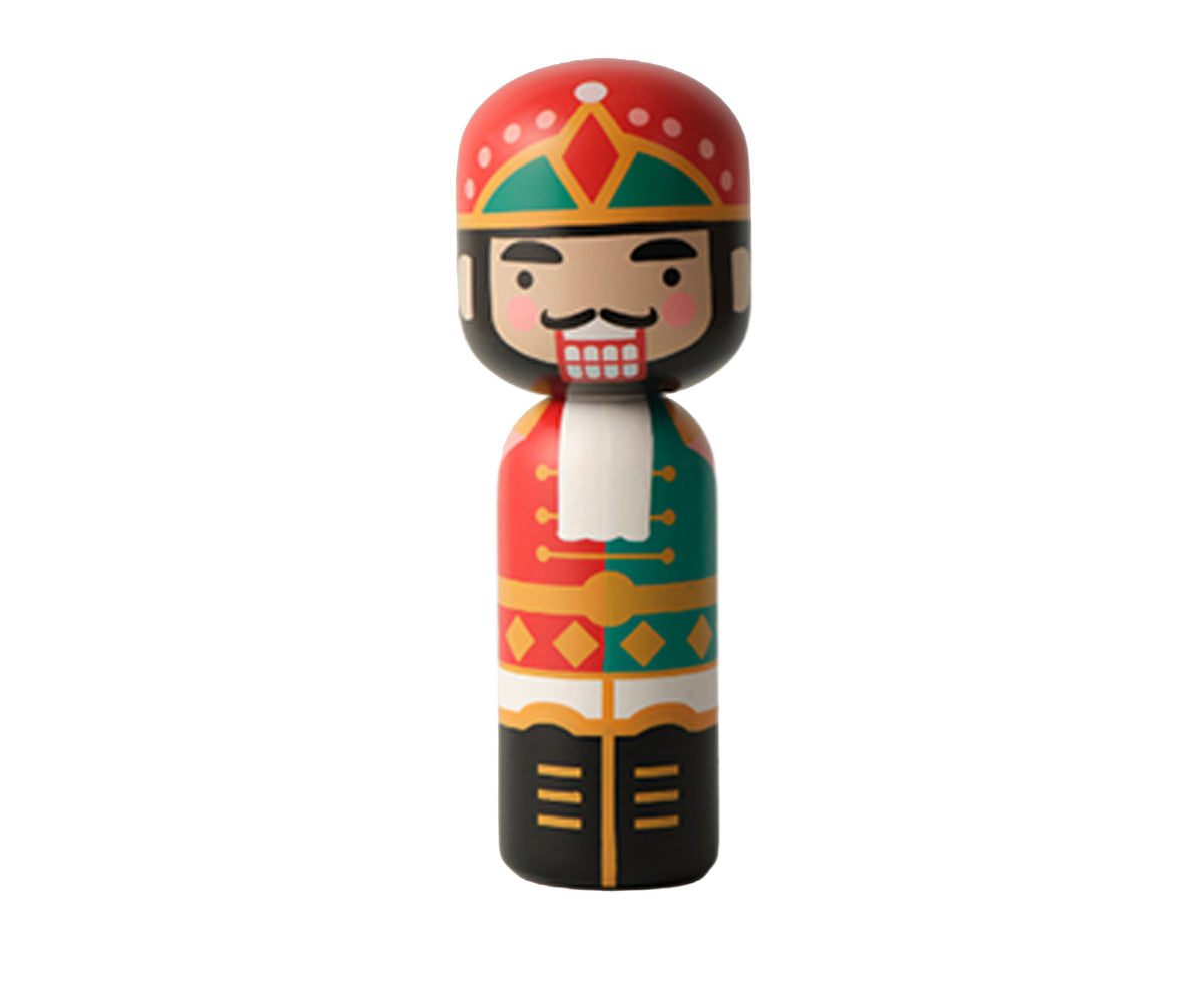 A colorful wooden nutcracker kokeshi doll with a red hat, green and red patterned coat, black pants, and a white beard, isolated on a white background.