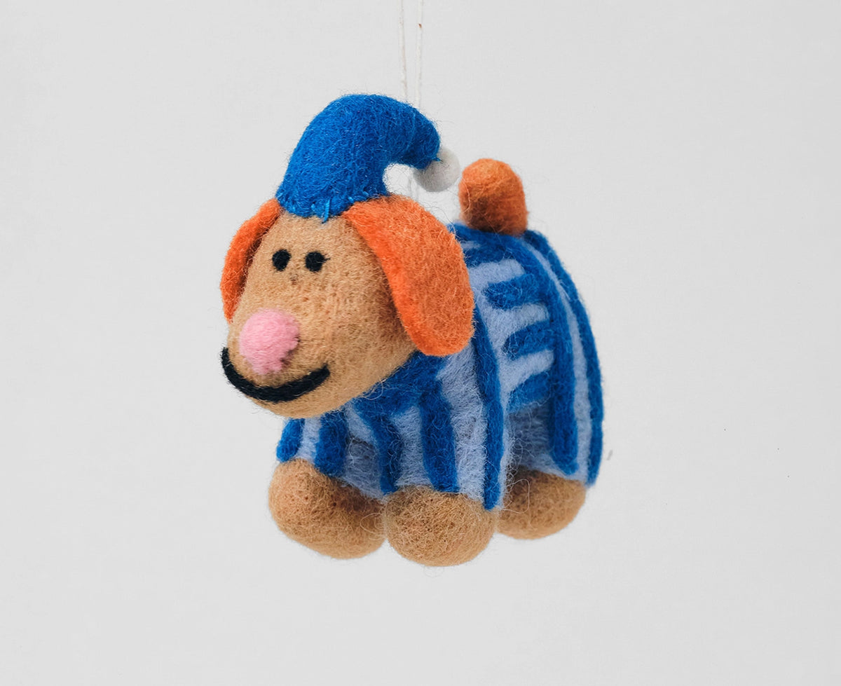 A felt dog Christmas ornament wearing a blue pointed hat and a blue-and-white striped sweater, with orange floppy ears and a pink nose.