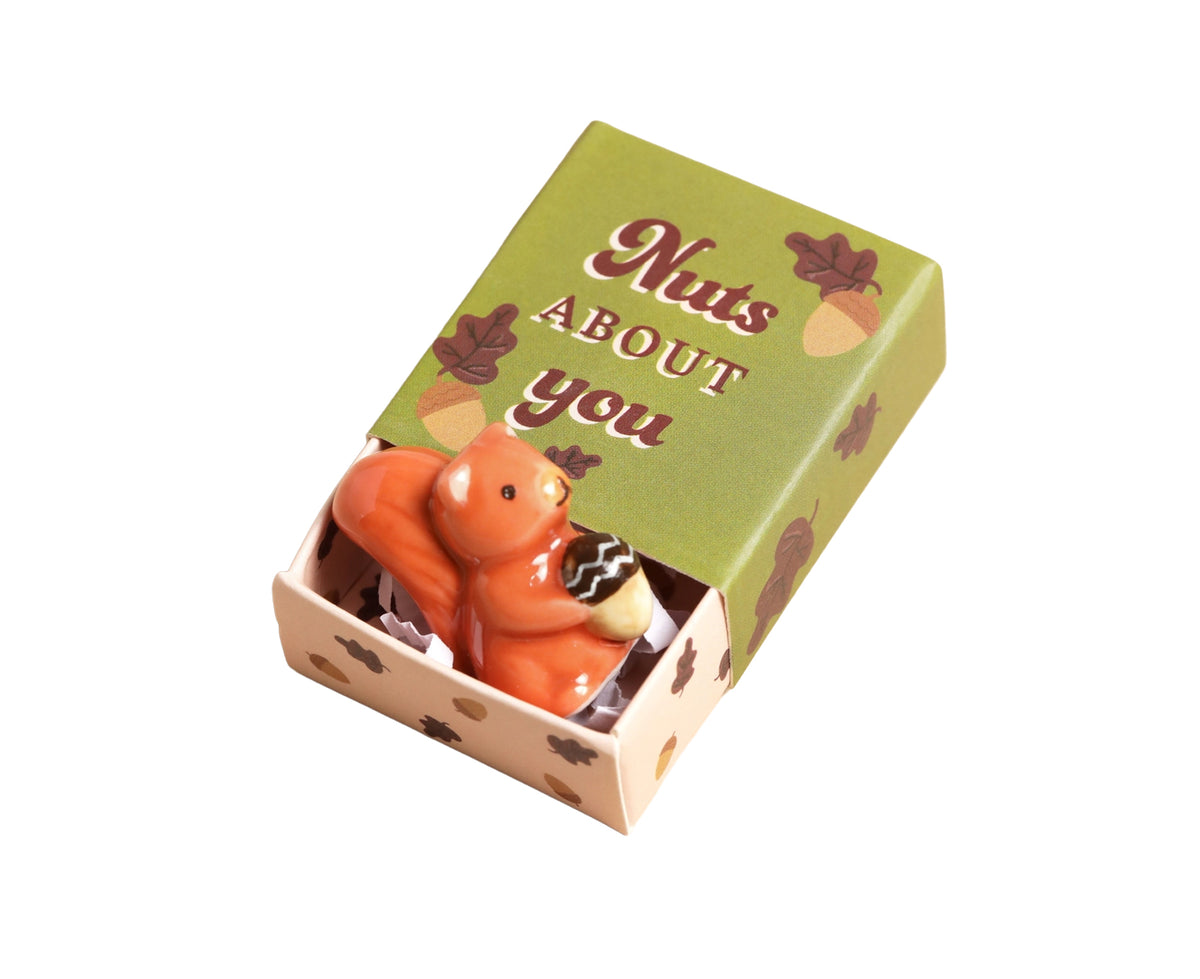 ceramic orange squirrel figurine in a green box.